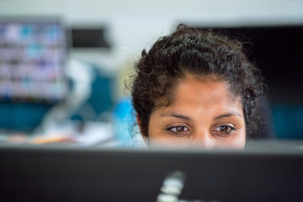 Illustratie van de juiste zithouding en ergonomie bij het werken achter een pc, met aandacht voor rug-, nek- en armpositioner